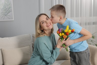 Photo of Happy Mother's Day. Son greeting his mom with flowers at home