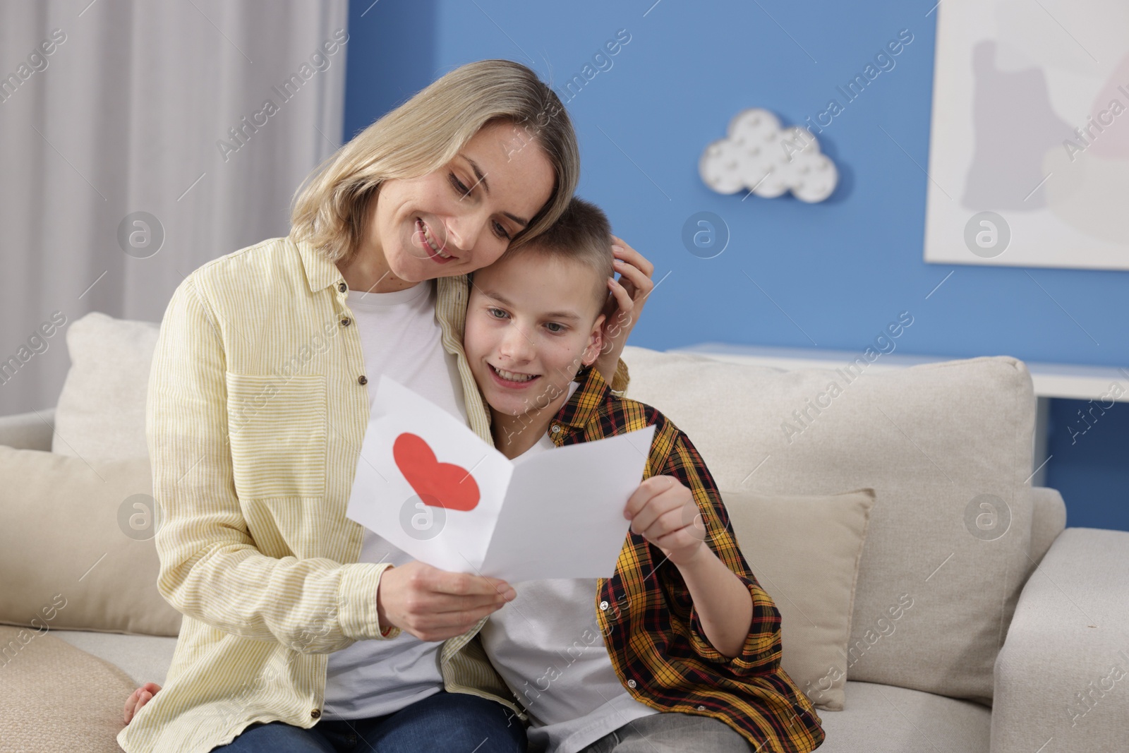 Photo of Happy Mother's Day. Son greeting his mom with card at home