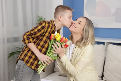 Photo of Happy Mother's Day. Son greeting his mom with flowers at home