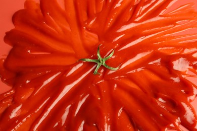 Photo of Slathered ketchup as smashed tomato on red background, above view