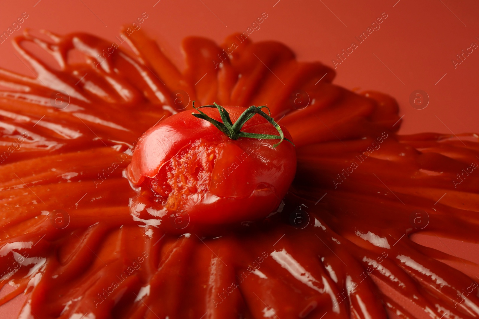 Photo of Tasty ketchup and tomato on red background, closeup