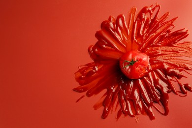 Photo of Tasty ketchup and tomato on red background, top view. Space for text