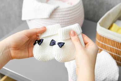 Photo of Woman with baby socks at home, closeup