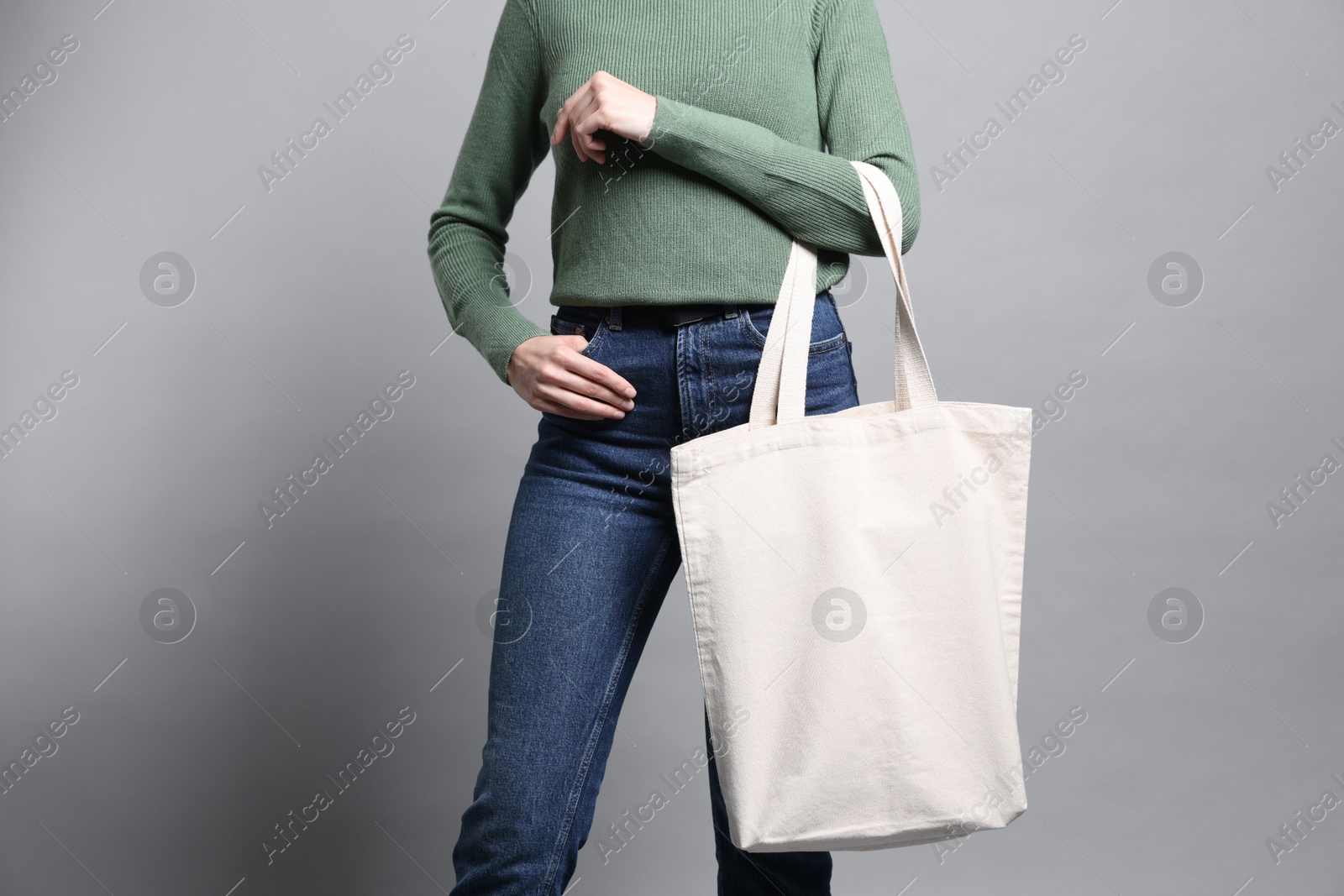 Photo of Woman with blank shopper bag on grey background, closeup. Mockup for design