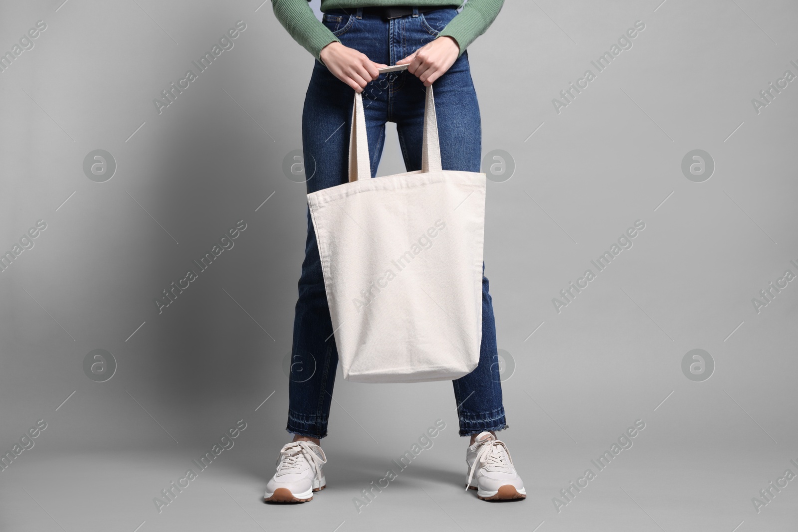 Photo of Woman with blank shopper bag on grey background, closeup. Mockup for design