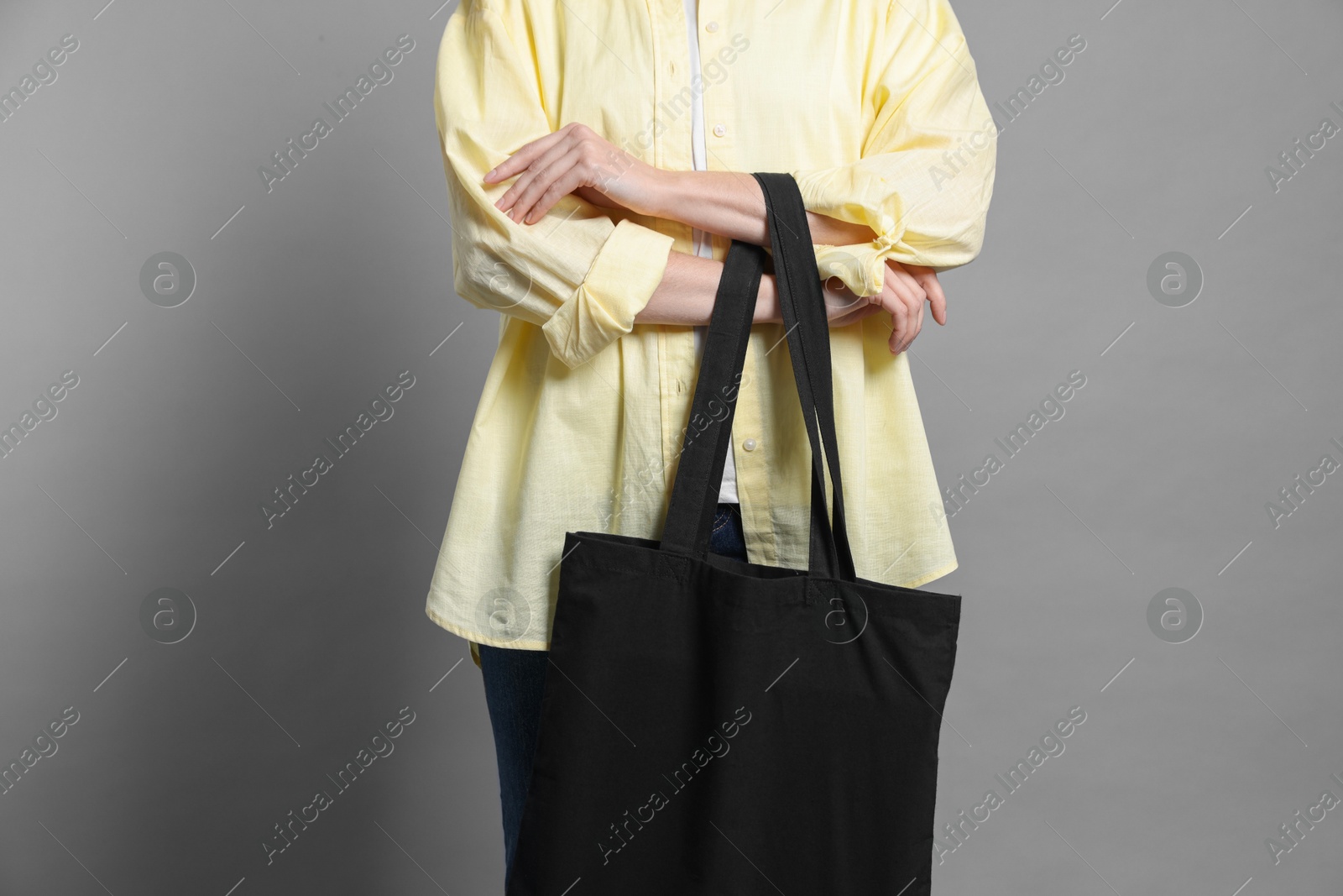 Photo of Woman with blank shopper bag on grey background, closeup. Mockup for design