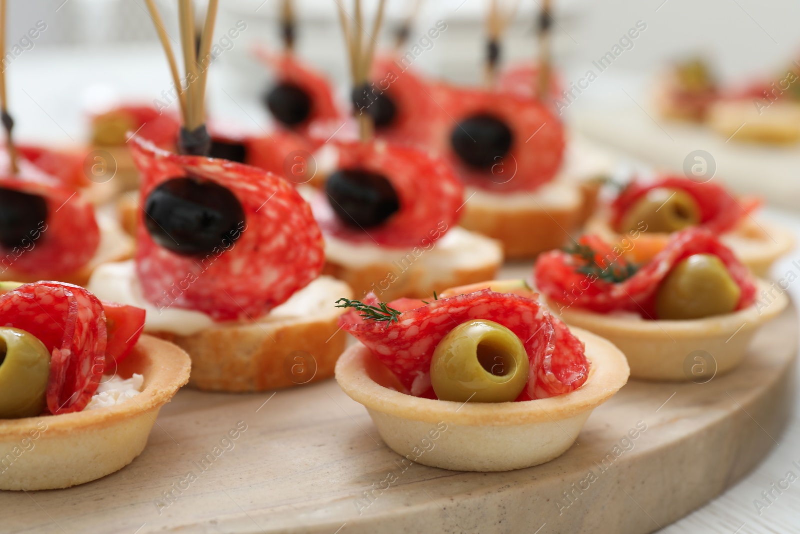 Photo of Many different tasty canapes on white wooden table, closeup