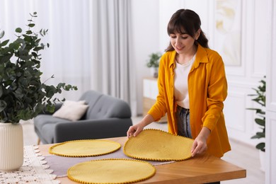 Woman setting table for dinner at home