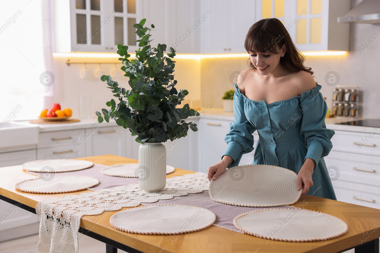 Photo of Woman setting table for dinner at home