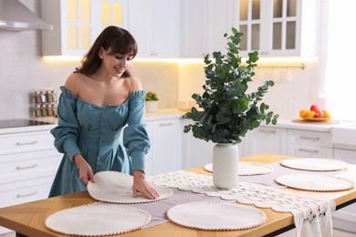 Woman setting table for dinner at home