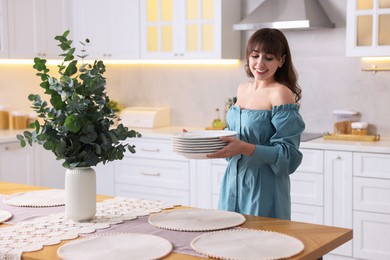 Woman setting table for dinner at home