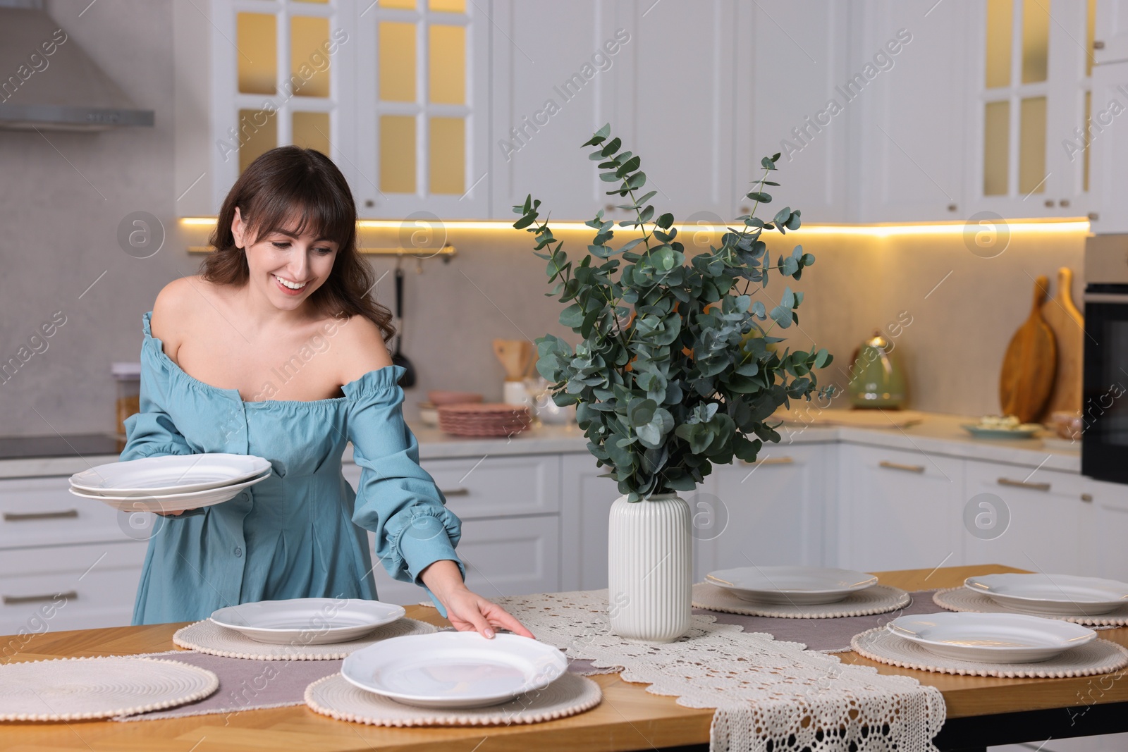 Photo of Woman setting table for dinner at home