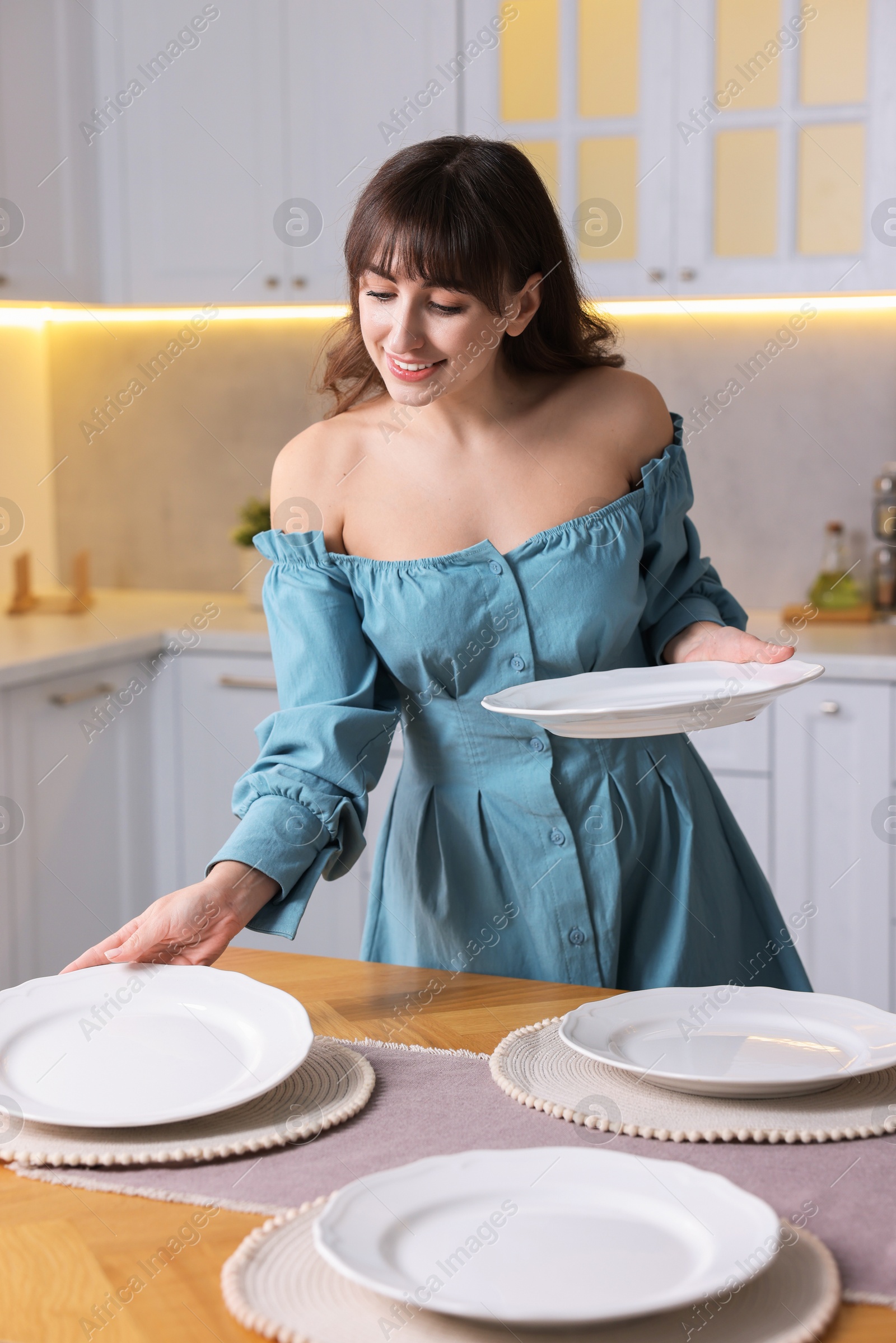 Photo of Woman setting table for dinner at home