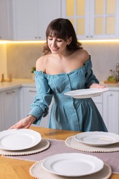 Photo of Woman setting table for dinner at home