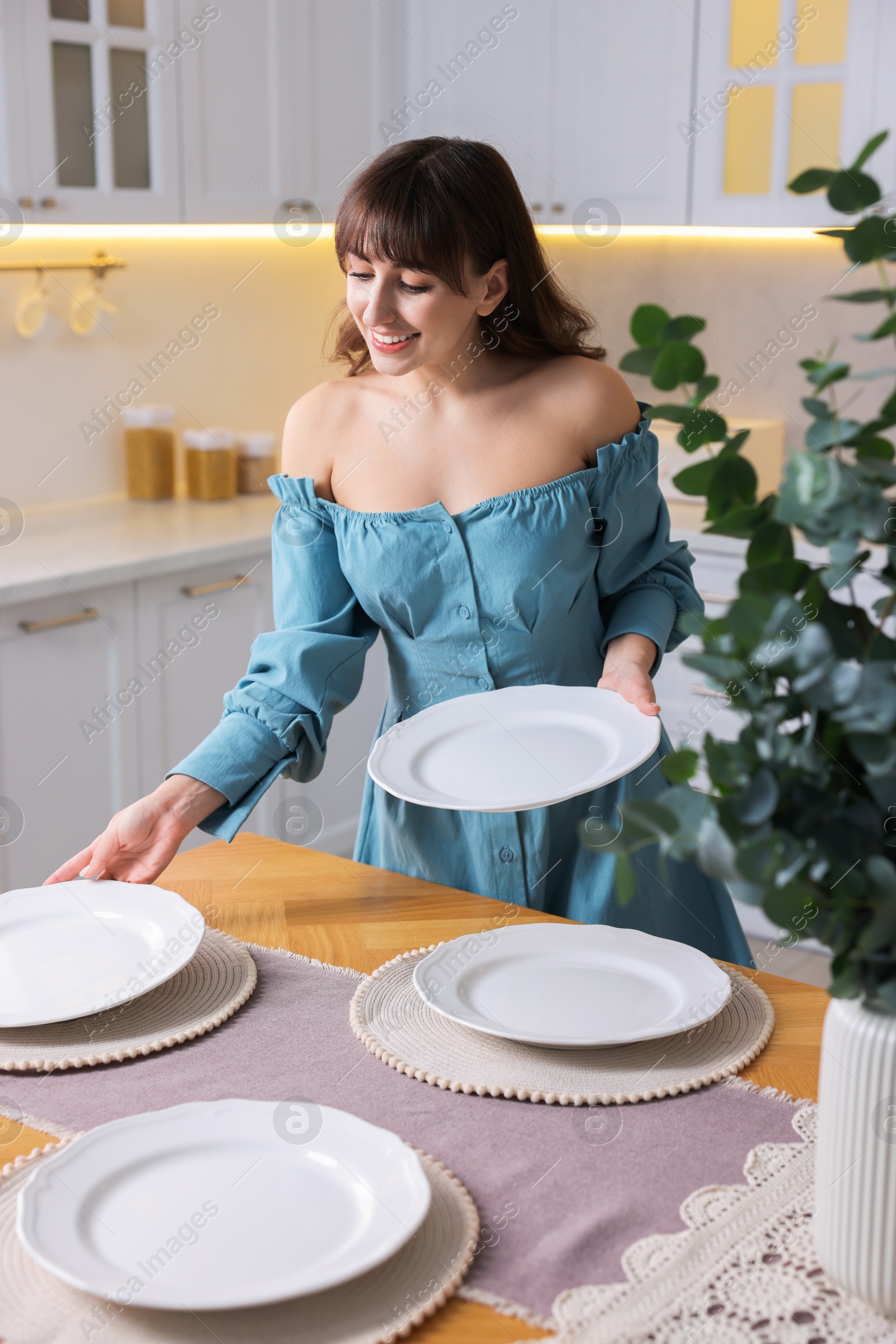 Photo of Woman setting table for dinner at home