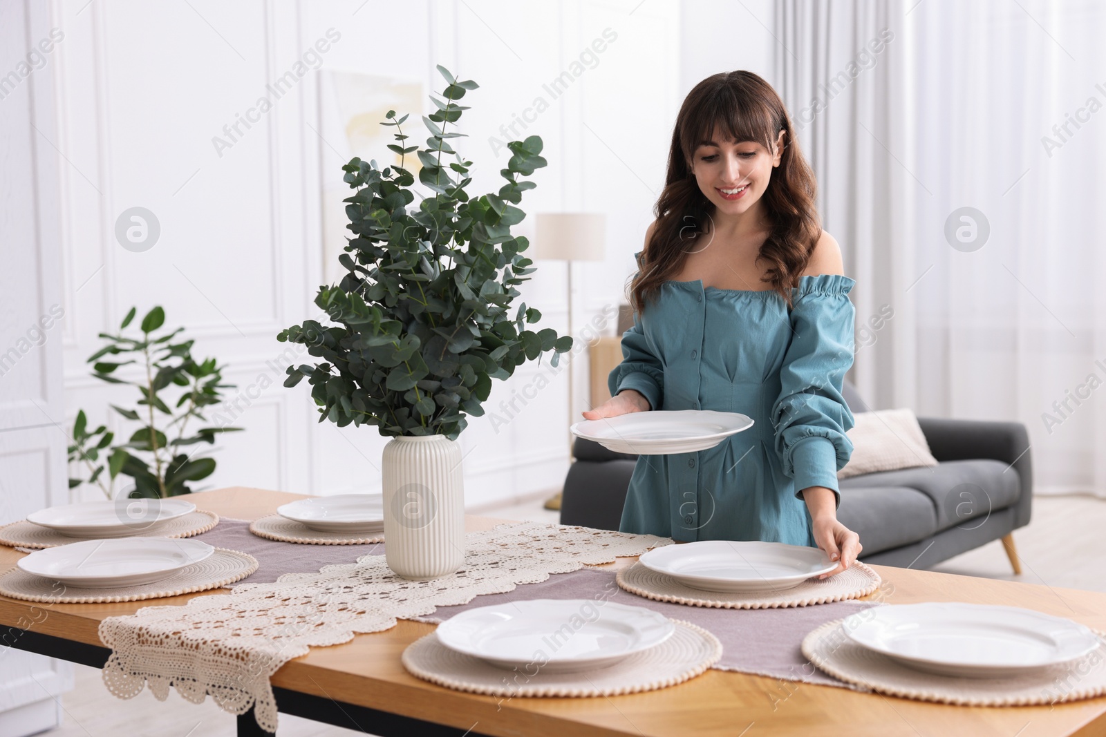 Photo of Woman setting table for dinner at home