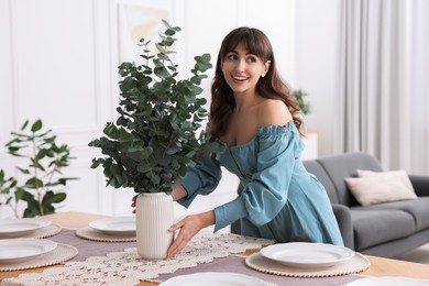 Woman setting table for dinner at home