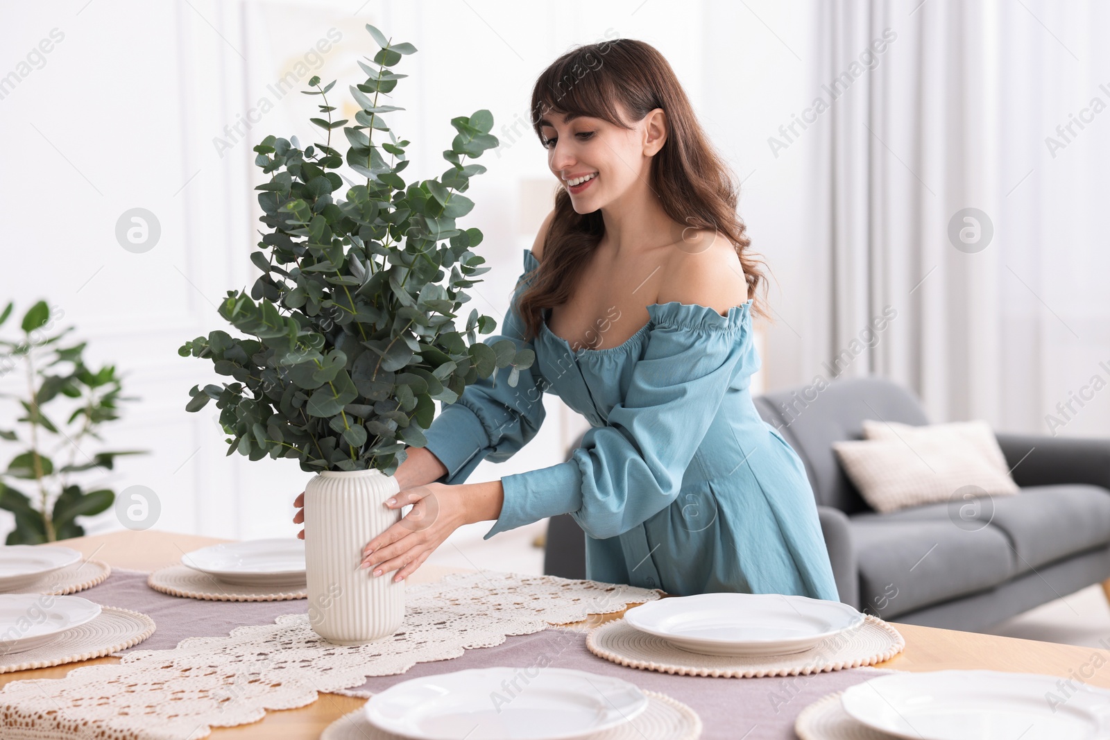 Photo of Woman setting table for dinner at home