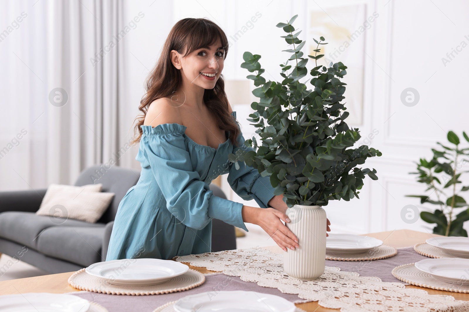 Photo of Woman setting table for dinner at home