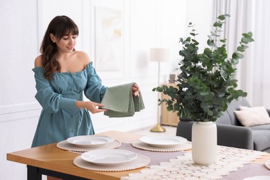 Photo of Woman setting table for dinner at home