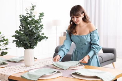 Photo of Woman setting table for dinner at home