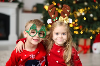 Photo of Cute little children in Christmas sweaters at home