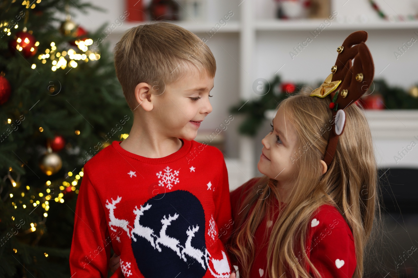 Photo of Adorable little kids in Christmas sweaters at home