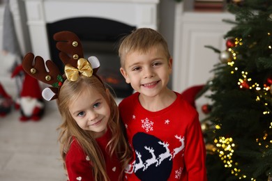 Photo of Adorable little kids in Christmas sweaters at home