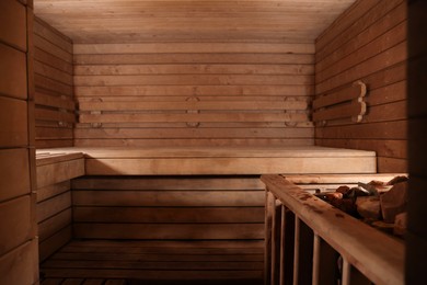 Photo of Wooden sauna with bench and hot stones