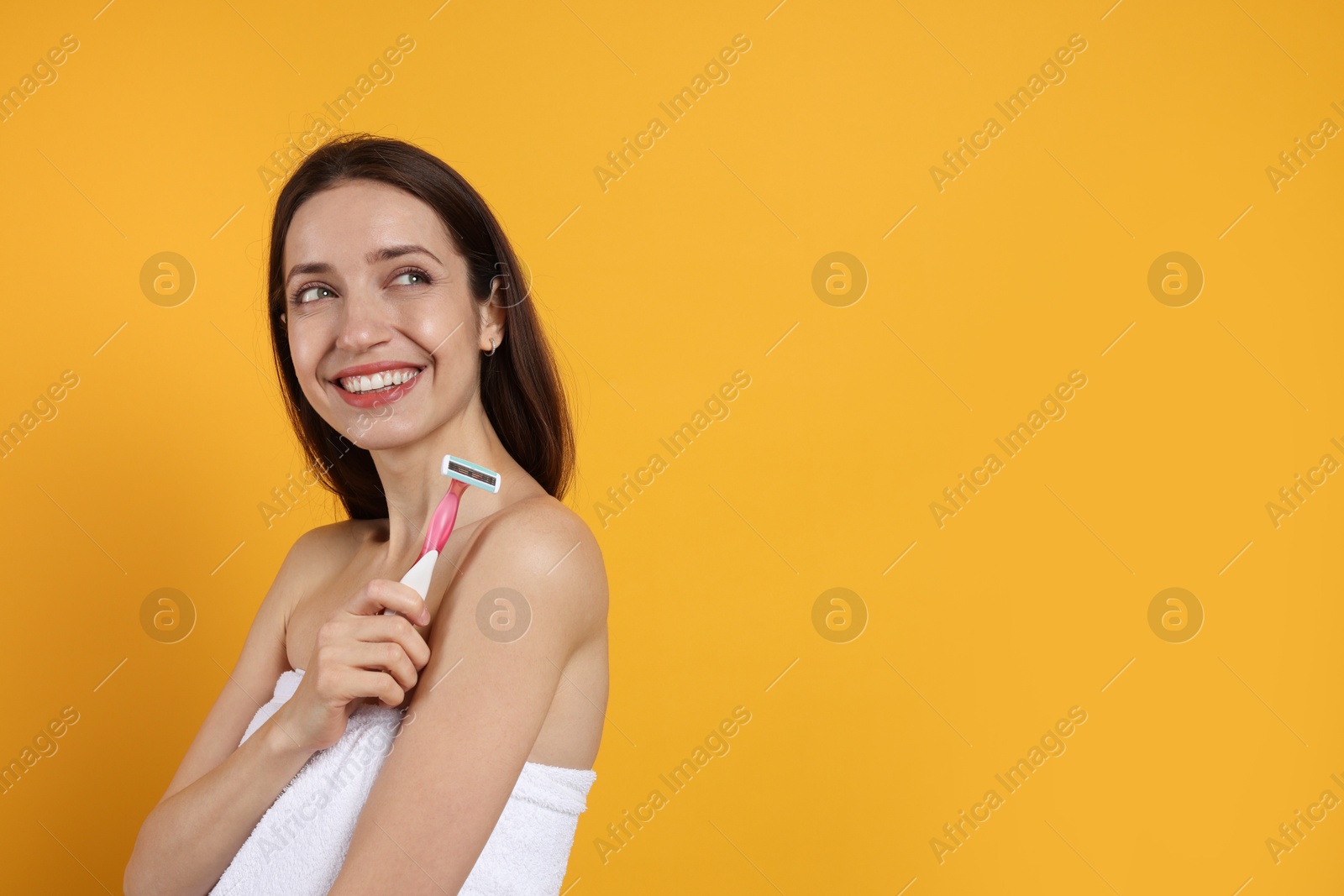 Photo of Happy woman with razor on orange background, space for text. Hair removal tool