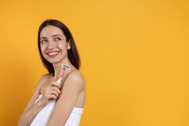 Photo of Happy woman with razor on orange background, space for text. Hair removal tool