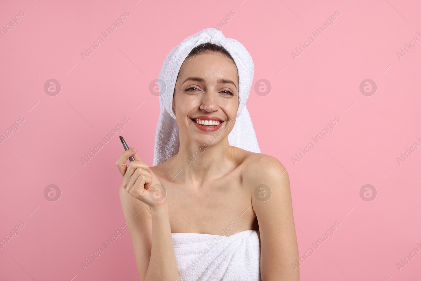 Photo of Happy woman with tweezers on pink background. Mustache removal tool