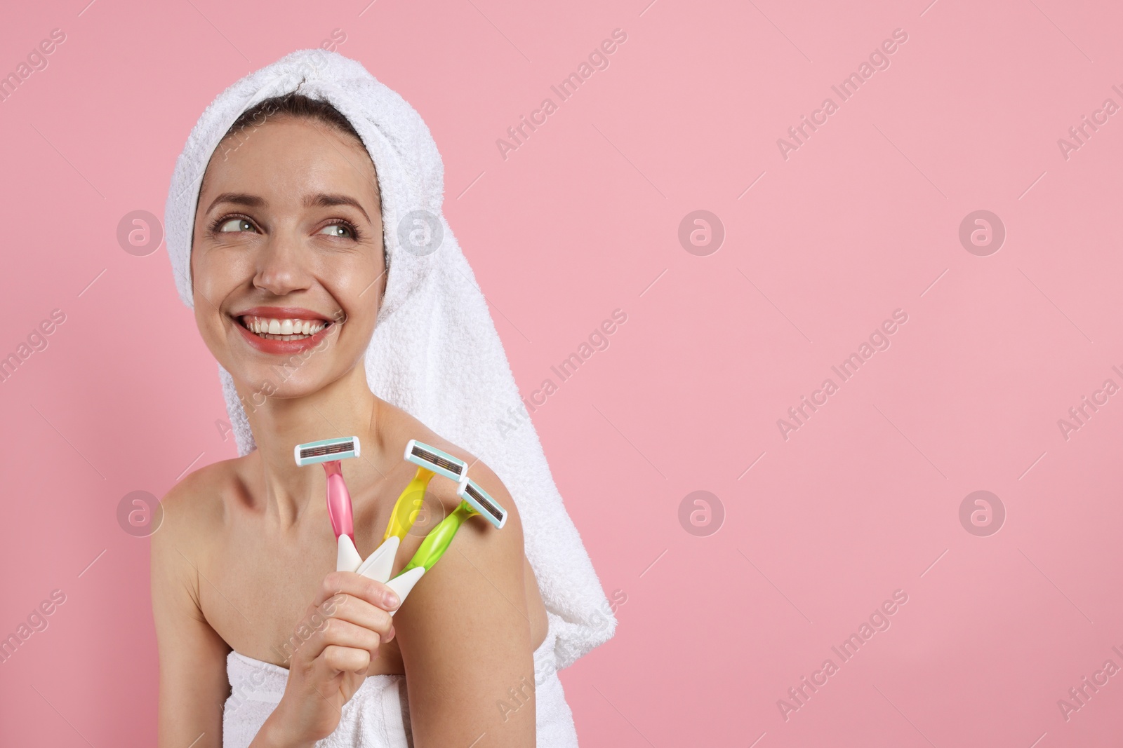 Photo of Happy woman with different razors on pink background, space for text. Hair removal tool