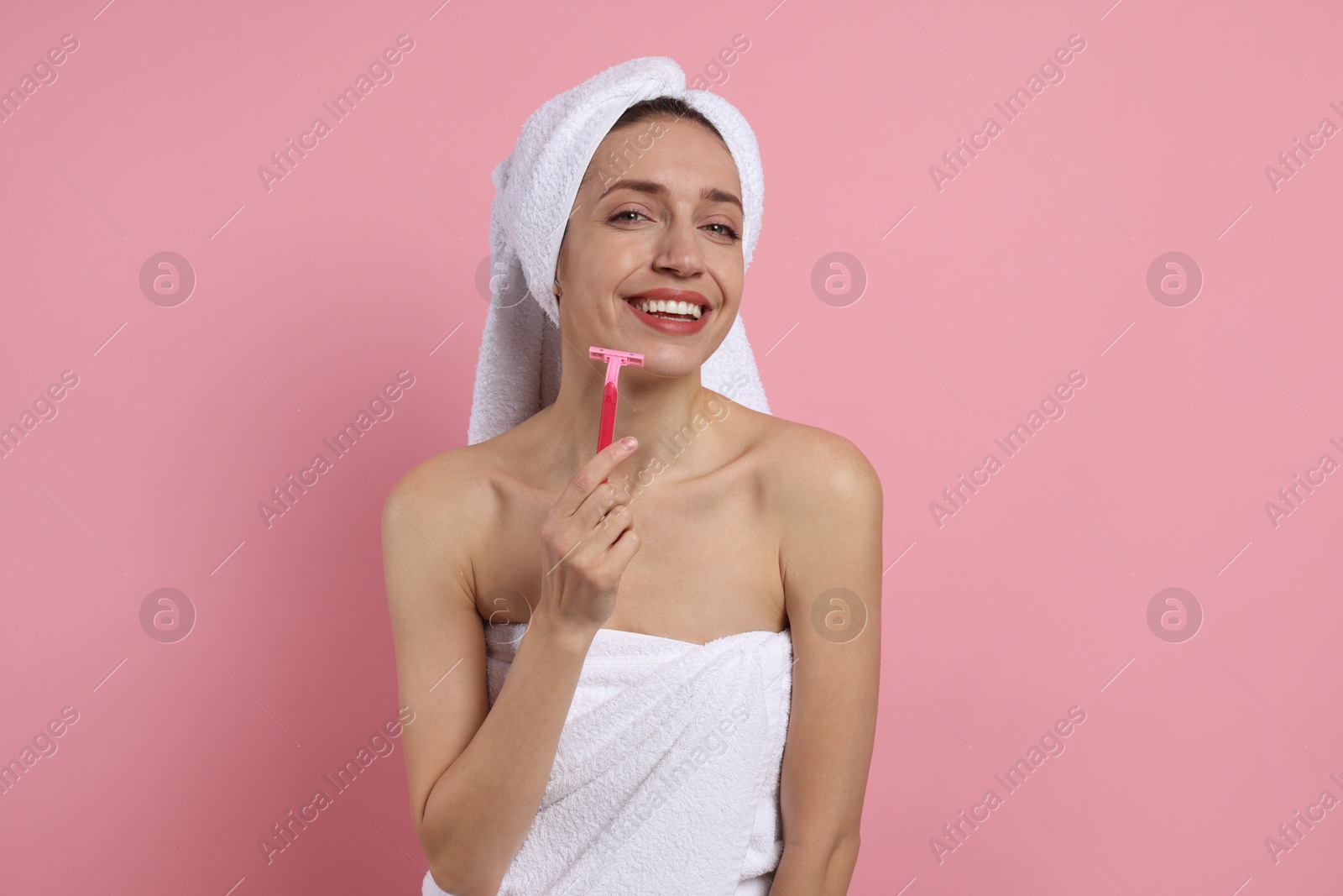 Photo of Happy woman shaving her facial hair with razor on pink background