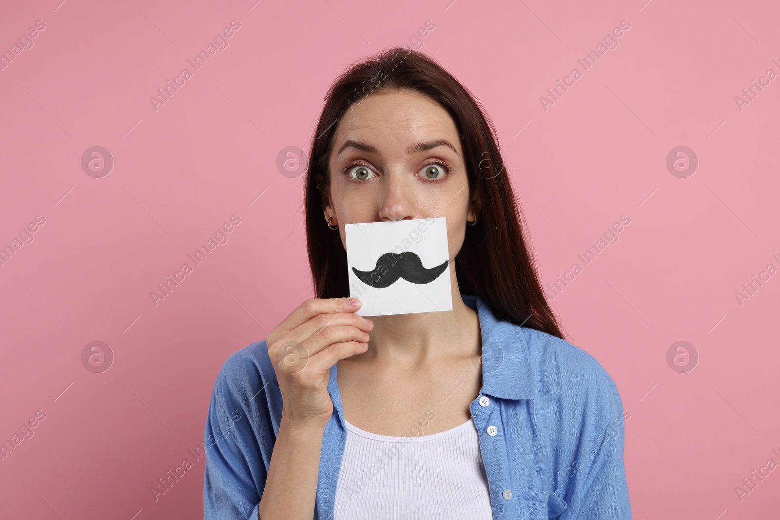 Photo of Woman holding paper with drawn mustache on pink background