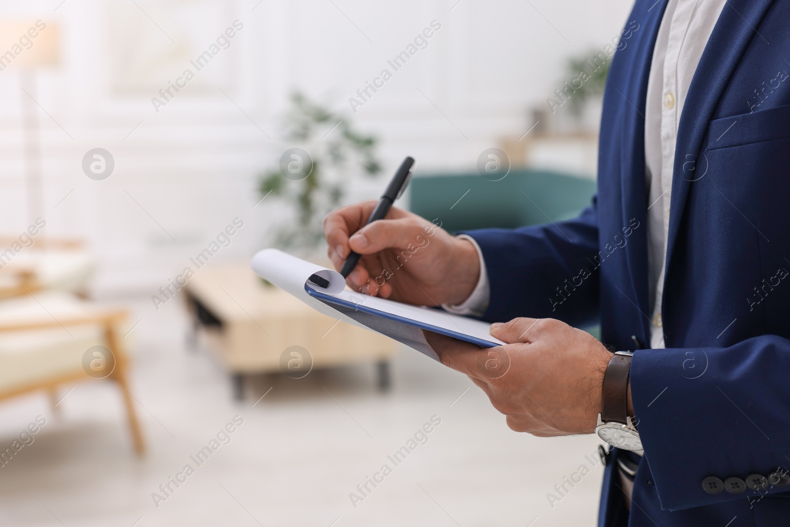 Photo of Real estate appraisal. Inspector with clipboard conducting property valuation at home, closeup. Space for text