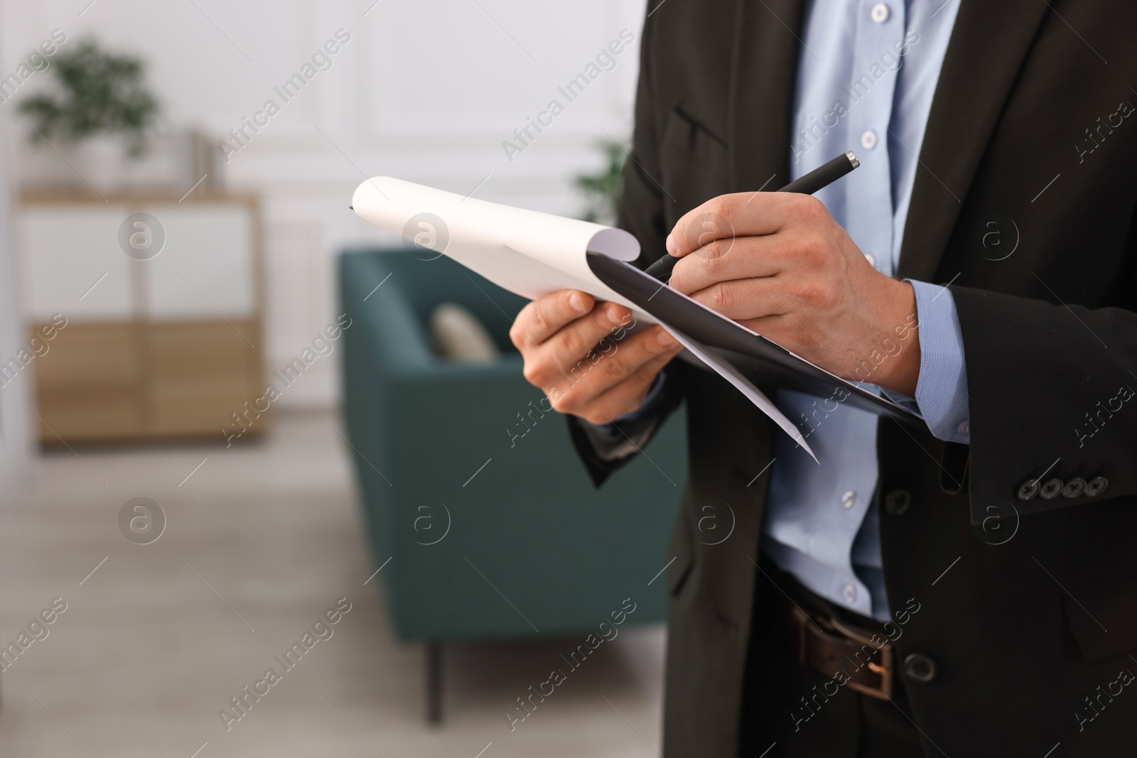 Photo of Real estate appraisal. Inspector with clipboard conducting property valuation at home, closeup. Space for text