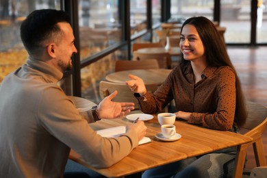 Photo of Colleagues working together at table in cafe