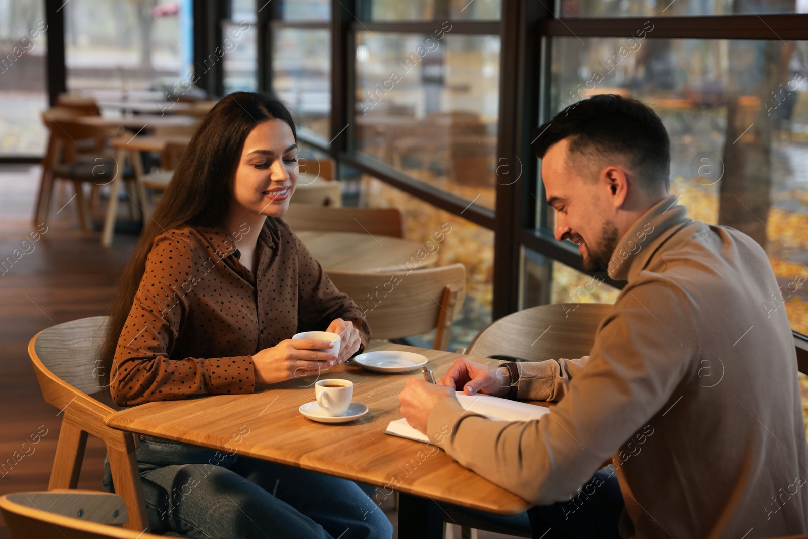 Photo of Colleagues working together at table in cafe