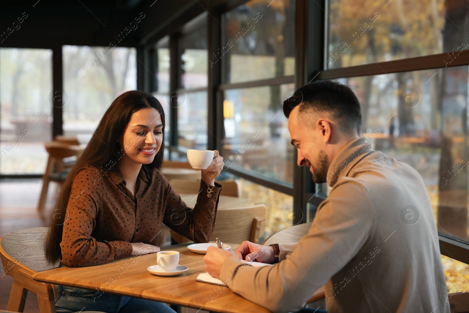 Photo of Colleagues working together at table in cafe