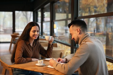 Photo of Colleagues working together at table in cafe