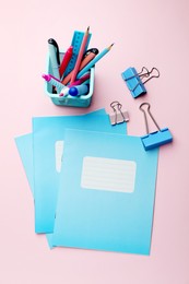 Photo of Copybooks and other school stationery on pink background, flat lay