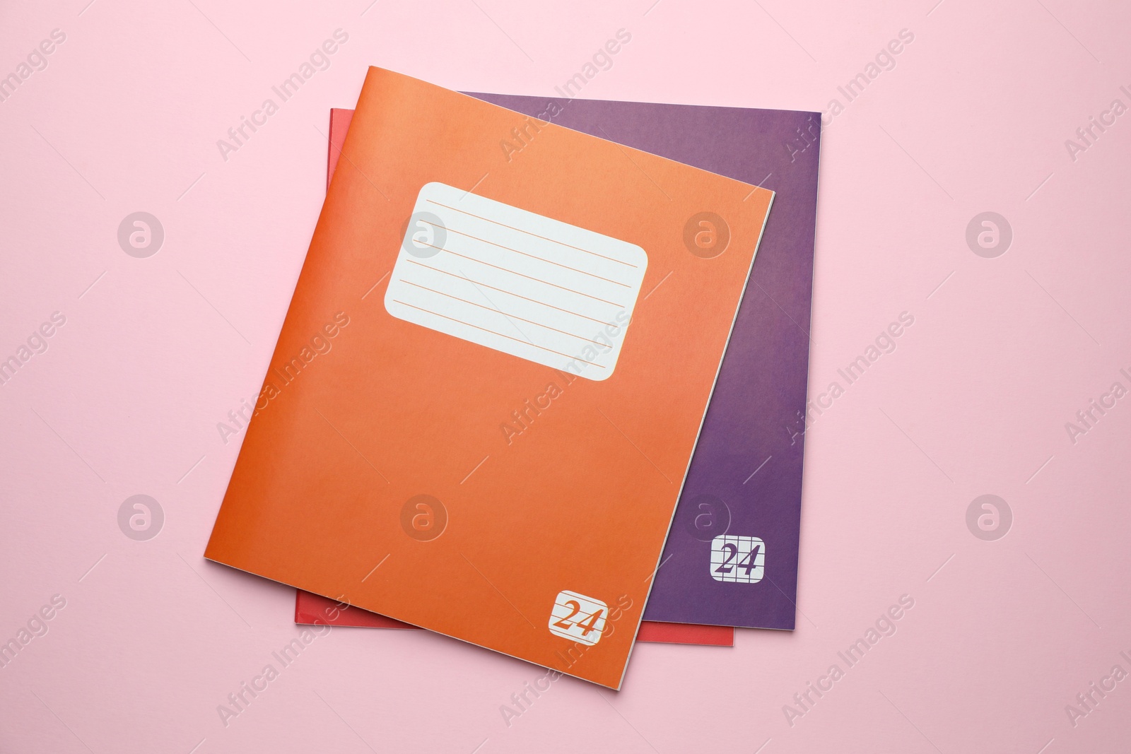 Photo of Colorful copybooks on pink background, flat lay. School stationery