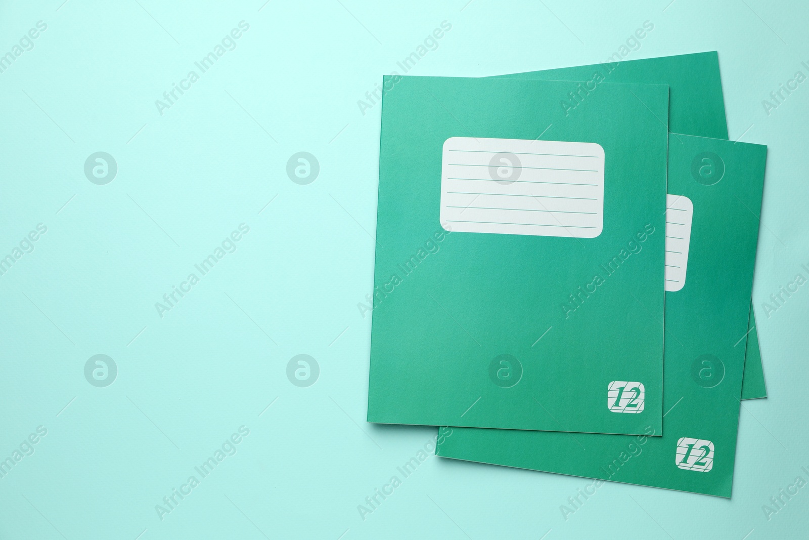 Photo of Colorful copybooks on light blue background, flat lay. School stationery