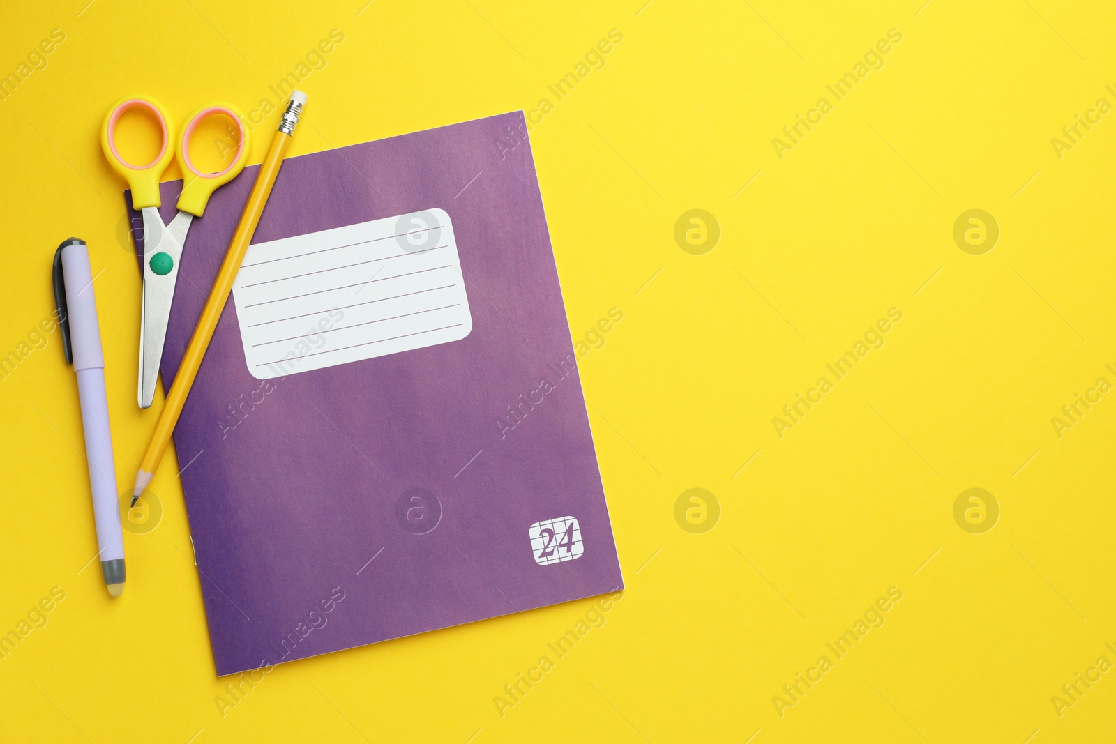 Photo of Copybook and other school stationery on yellow background, flat lay. Space for text