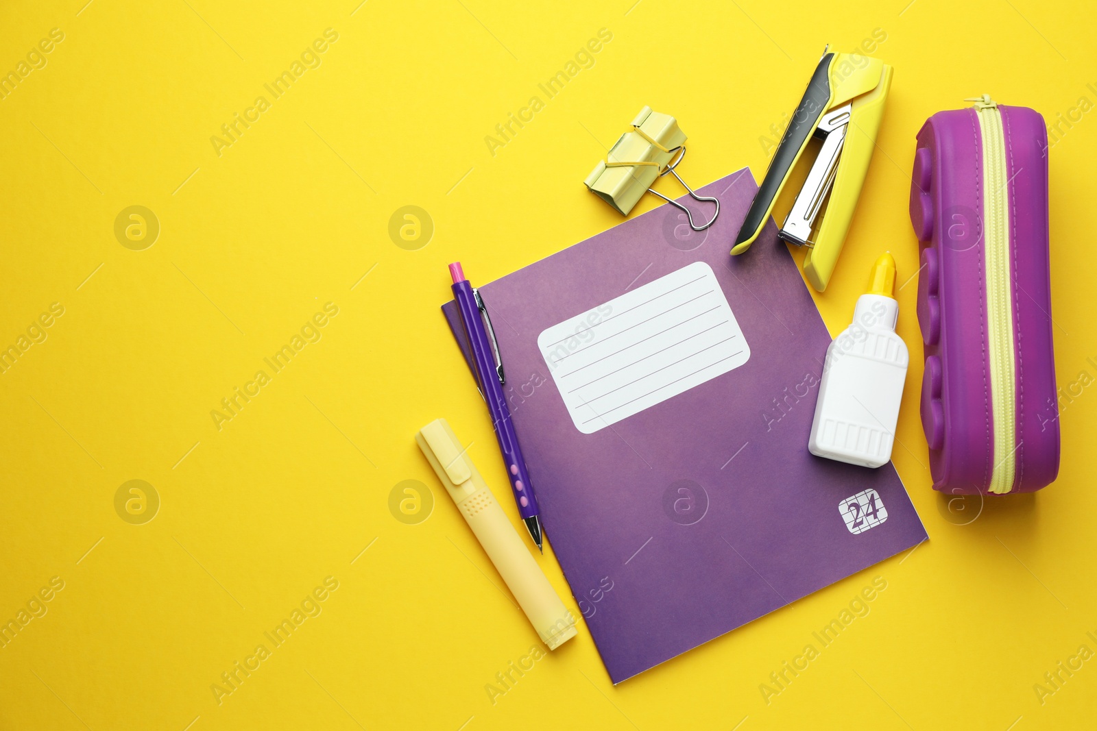 Photo of Copybook and other school stationery on yellow background, flat lay. Space for text