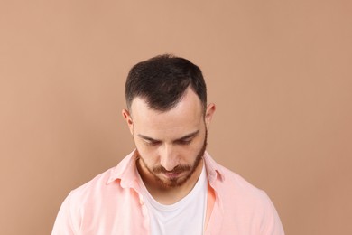 Photo of Baldness problem. Man with receding hairline on beige background