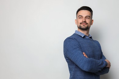 Portrait of handsome middle aged man on light background, space for text