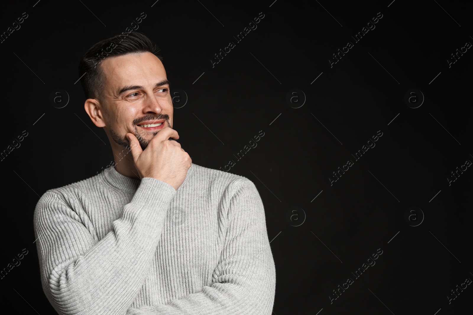 Photo of Portrait of handsome middle aged man on black background, space for text