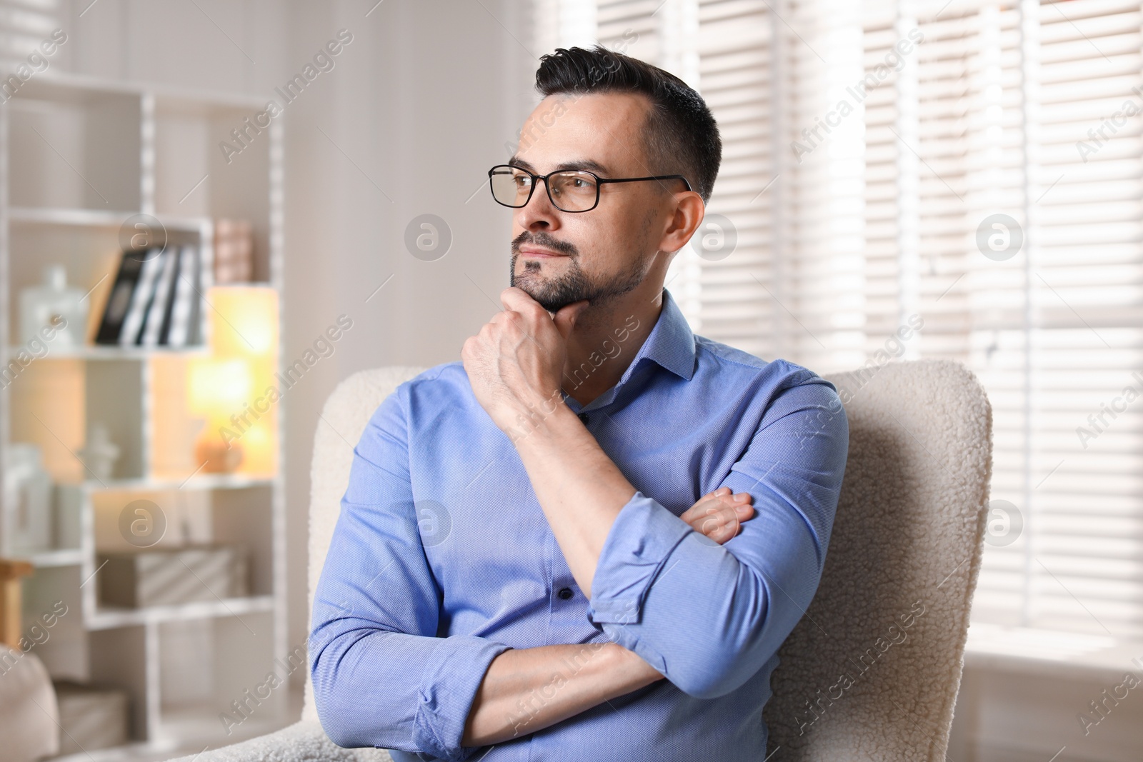 Photo of Handsome middle aged man in armchair indoors